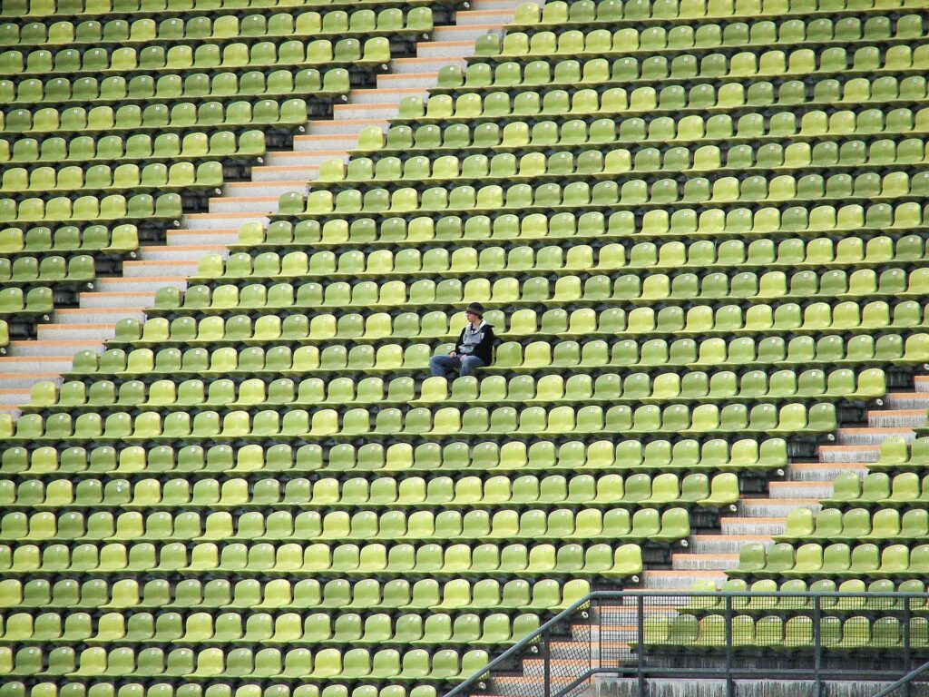 a person sits alone in a stadium